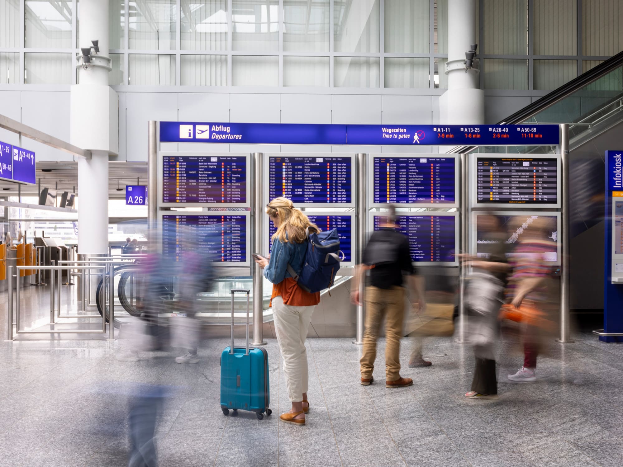 Reisende vor der Abflugtafel im Terminal des Flughafen Frankfurt – Aviation Security und Luftsicherheit am Frankfurt Airport