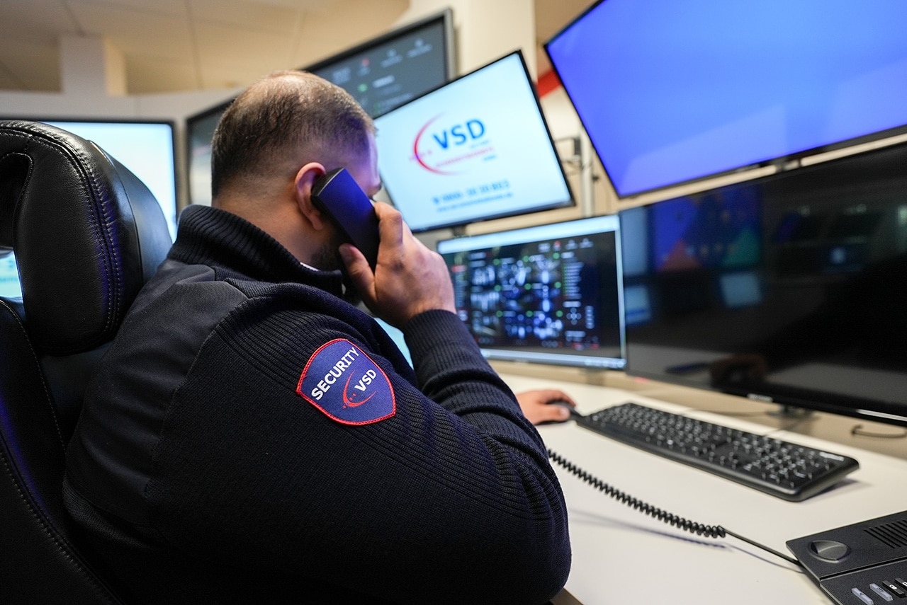 VSD Security-Mitarbeiter in der Notruf- und Serviceleitstelle beim Telefoneinsatz vor Überwachungsmonitoren mit Alarmmanagement-Software